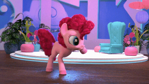 a pink pony is standing on a stage in front of a blue chair