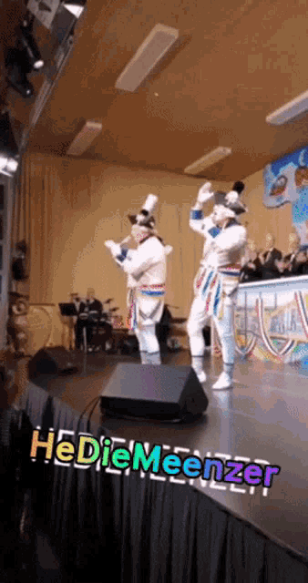 a group of people dancing on a stage with the words hediemeenzer written on the bottom