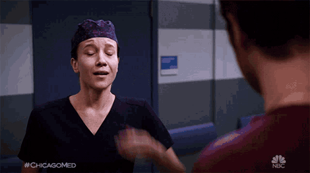 a woman in scrubs talks to a man in a nbc advertisement