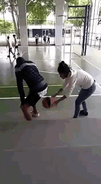 a group of people are playing basketball on a court .