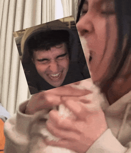 a woman holding a picture of a man 's face