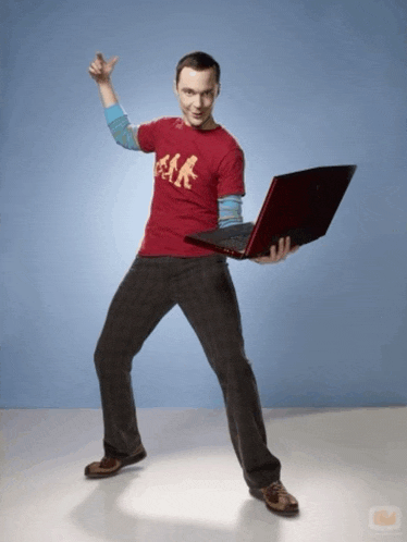 a man in a red shirt holds a laptop in his hands