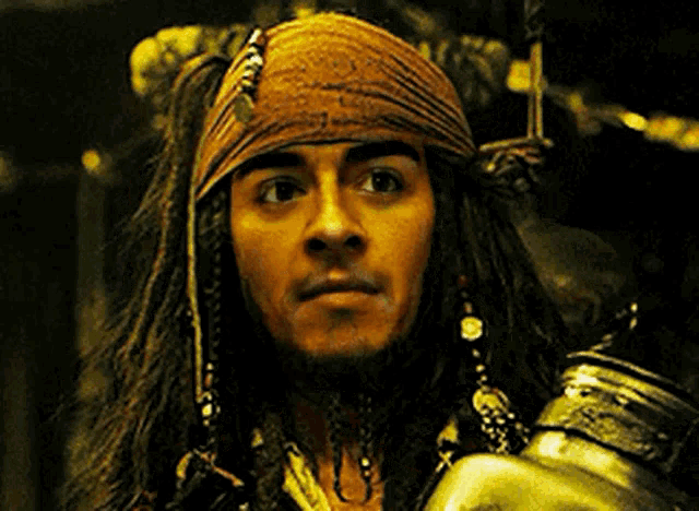 a man with long hair and dreadlocks is wearing a bandana and holding a bottle