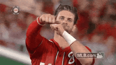 a man in a red shirt is giving a thumbs up