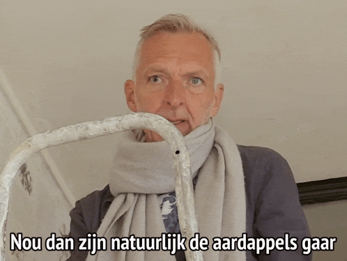 a man with a scarf around his neck and the words nou dan zijn natuurlijk de aardappels gaar above him