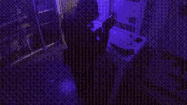 a man holding a gun in front of a sign that says " police swat "