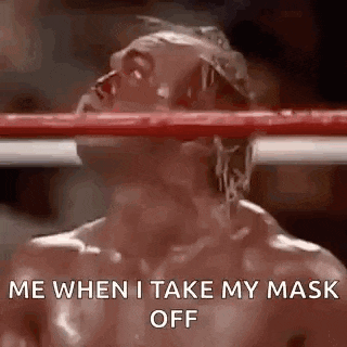 a man is standing in a boxing ring with his head in the ring and his face covered in blood .