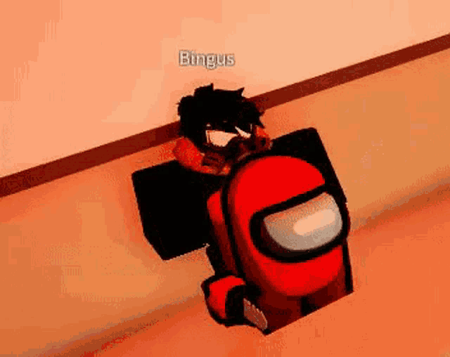 a man is standing next to a red among us character .