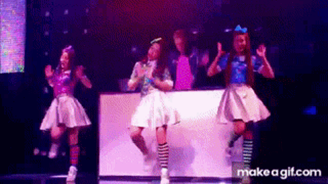 a group of girls are dancing on a stage .