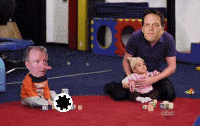 a man and a baby are playing with blocks and the abc logo is visible in the background