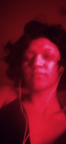 a blurry picture of a person wearing headphones in a red light