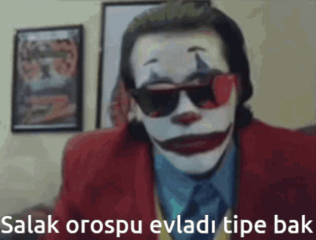 a picture of a clown wearing sunglasses and a red suit