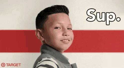a young boy is standing in front of a red and white striped wall with the words `` sup '' written on it .