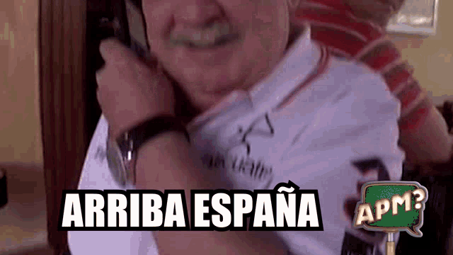 a man with a mustache is talking on a cell phone and the words arriba espana are above him