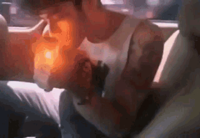 a man smoking a cigarette in the back seat of a car