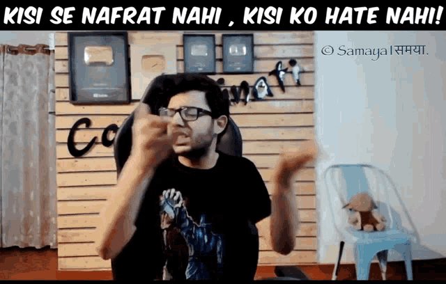 a man wearing glasses and a black shirt with the words kisi se nafrat nahi kisi ko hate nahi