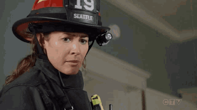 a woman wearing a fireman 's helmet with the number 19 seattle on it