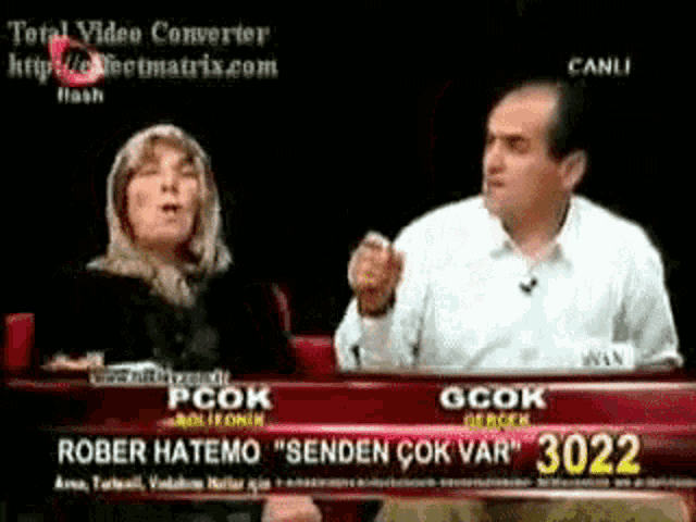 a man and a woman are sitting in front of a sign that says rober hatemo