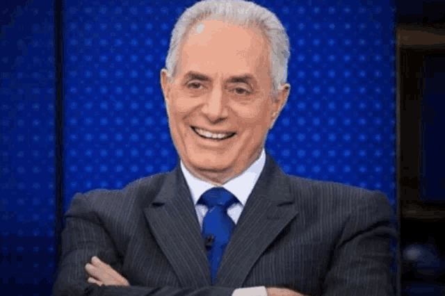 a man in a suit and tie is wearing a hooded cape and smiling