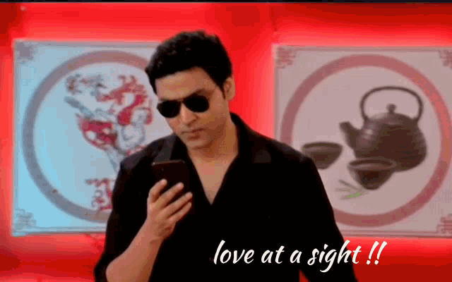 a man wearing sunglasses looks at his phone with the words love at a sight