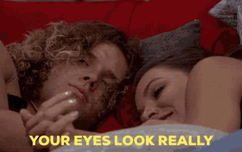 a man and a woman laying on a bed with the words your eyes look really