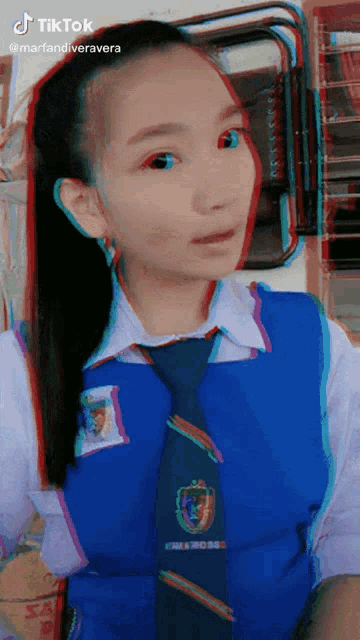a girl wearing a blue tie and a white shirt has tiktok written on the bottom