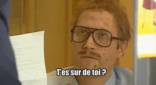 a man with glasses and a mustache is holding a piece of paper and says t 'es sur de toi ?
