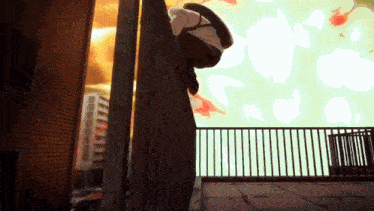 a person is hanging upside down from a fence in front of a city