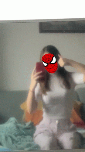 a woman wearing a spiderman mask takes a selfie