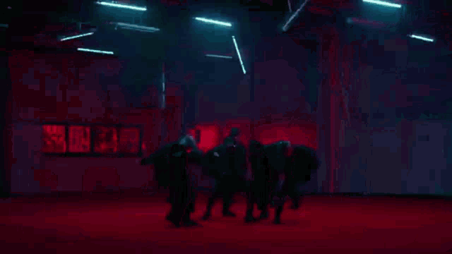 a group of young men are dancing together on a red carpet .