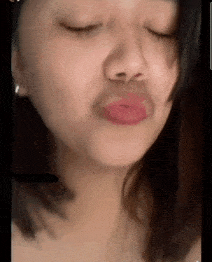 a close up of a woman 's face with her eyes closed and her mouth open