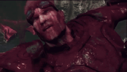 a video game character is covered in red liquid and has glowing eyes