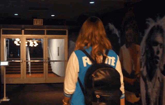 a girl wearing a blue jacket with the letter f on the back