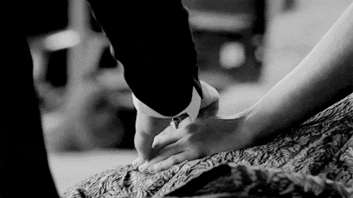 a man and woman are holding hands on a bed .