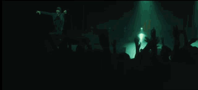 a man is playing a guitar in front of a crowd