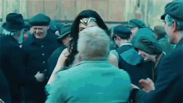 a woman in a wonder woman costume is standing in a crowd of people