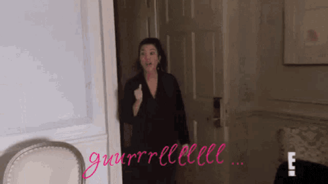 a woman giving a thumbs up in front of a door that says gurrrllleeee