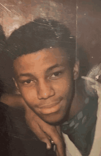 a young man with his arm around another man 's shoulder looks at the camera