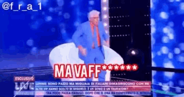 a man in a blue suit and orange tie is sitting in a chair with the word mavaff on the screen