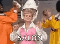 a woman is standing in front of a hair dryer with the word salon written on it .