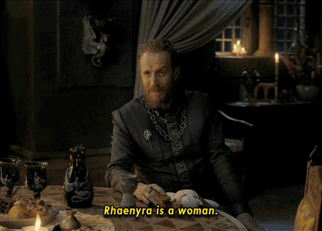a man sitting at a table with the words rhaenyra is a woman