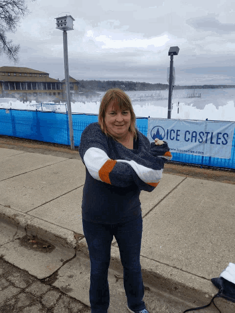 a woman stands in front of an ice castles sign
