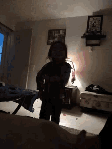 a woman is standing in a dark room with a picture on the wall that says ' i love you '