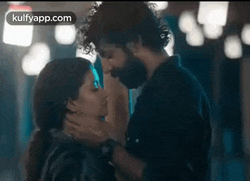 a man and a woman are kissing each other in a room .