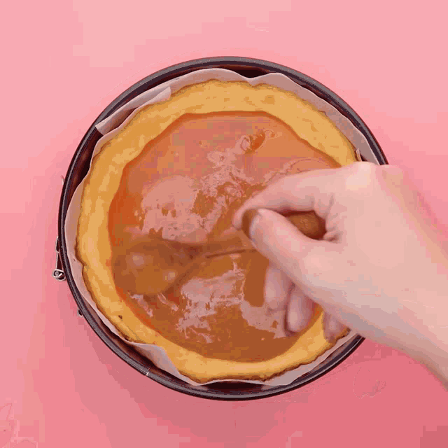 a person is spreading caramel on a pie