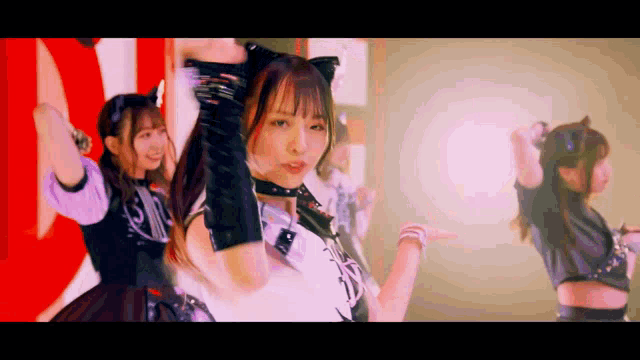 a girl in a cat ear costume is dancing with another girl
