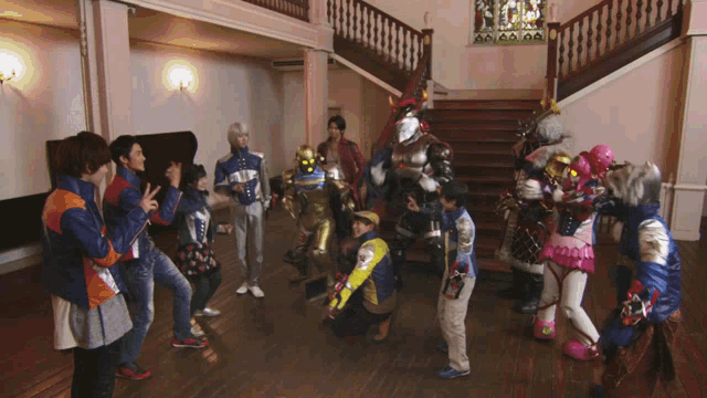 a group of people in costumes are standing in a room with stairs in the background