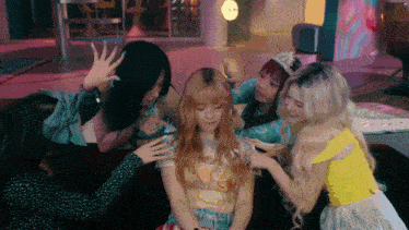 a group of girls are sitting on a couch playing with each other