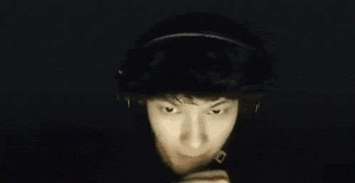 a man wearing headphones and a hat is making a funny face .