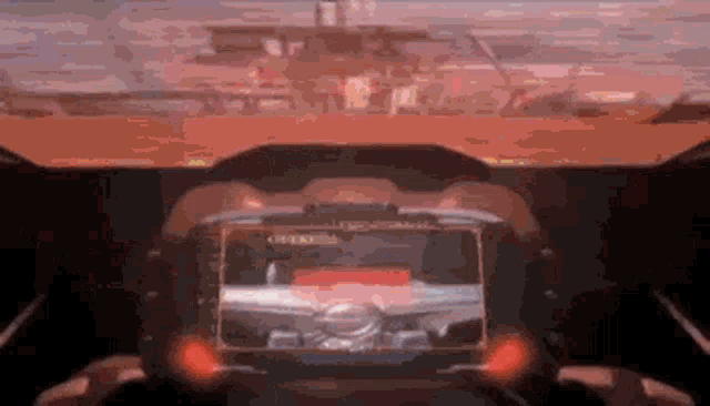 a person is driving a car with a steering wheel and a screen .